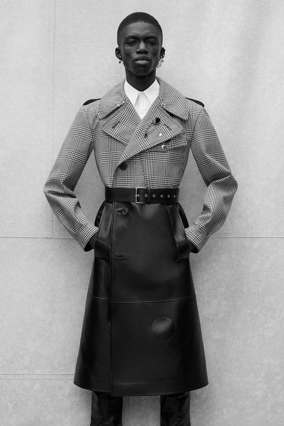 This photo features an editorial image of a woman of color wearing a sleek, sophisticated outfit from beloved fashion designer Alexander McQueen. 